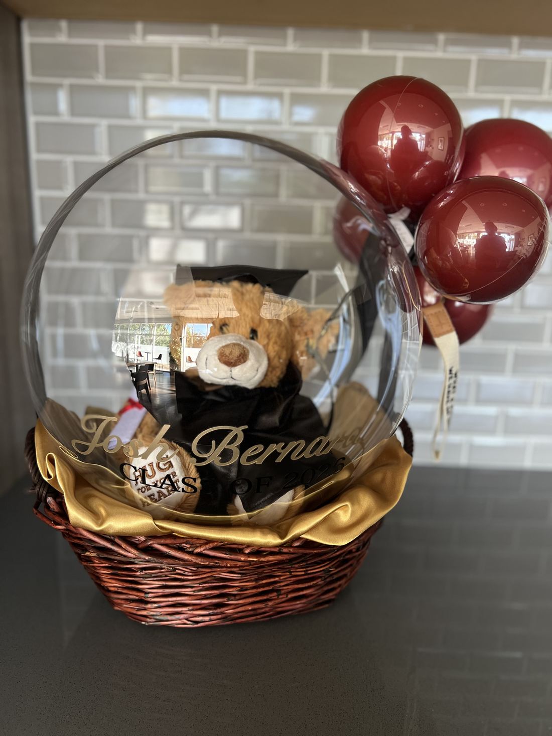 Graduation gift basket with plush bear and burgundy balloons